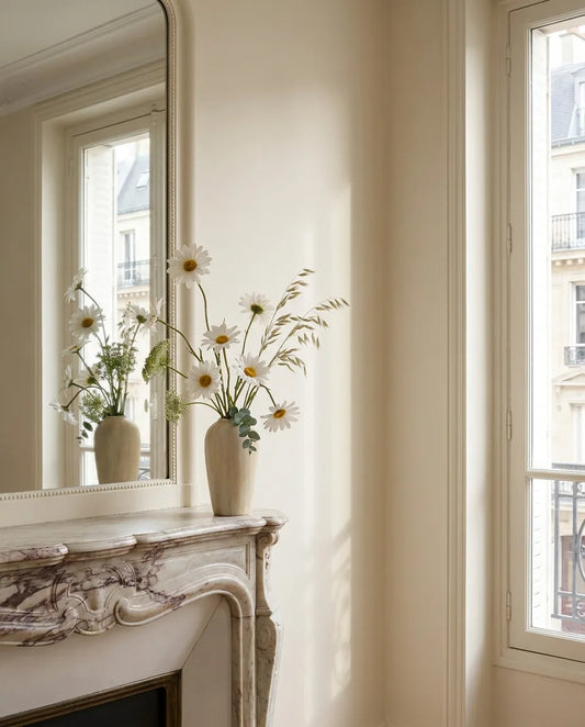 bouquet de fleurs artificielles sur une table basse dans un salon baigné de lumière naturelle