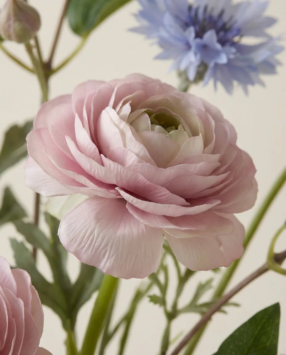 Gros plan sur les renoncules artificielles du bouquet Prairie Bleue