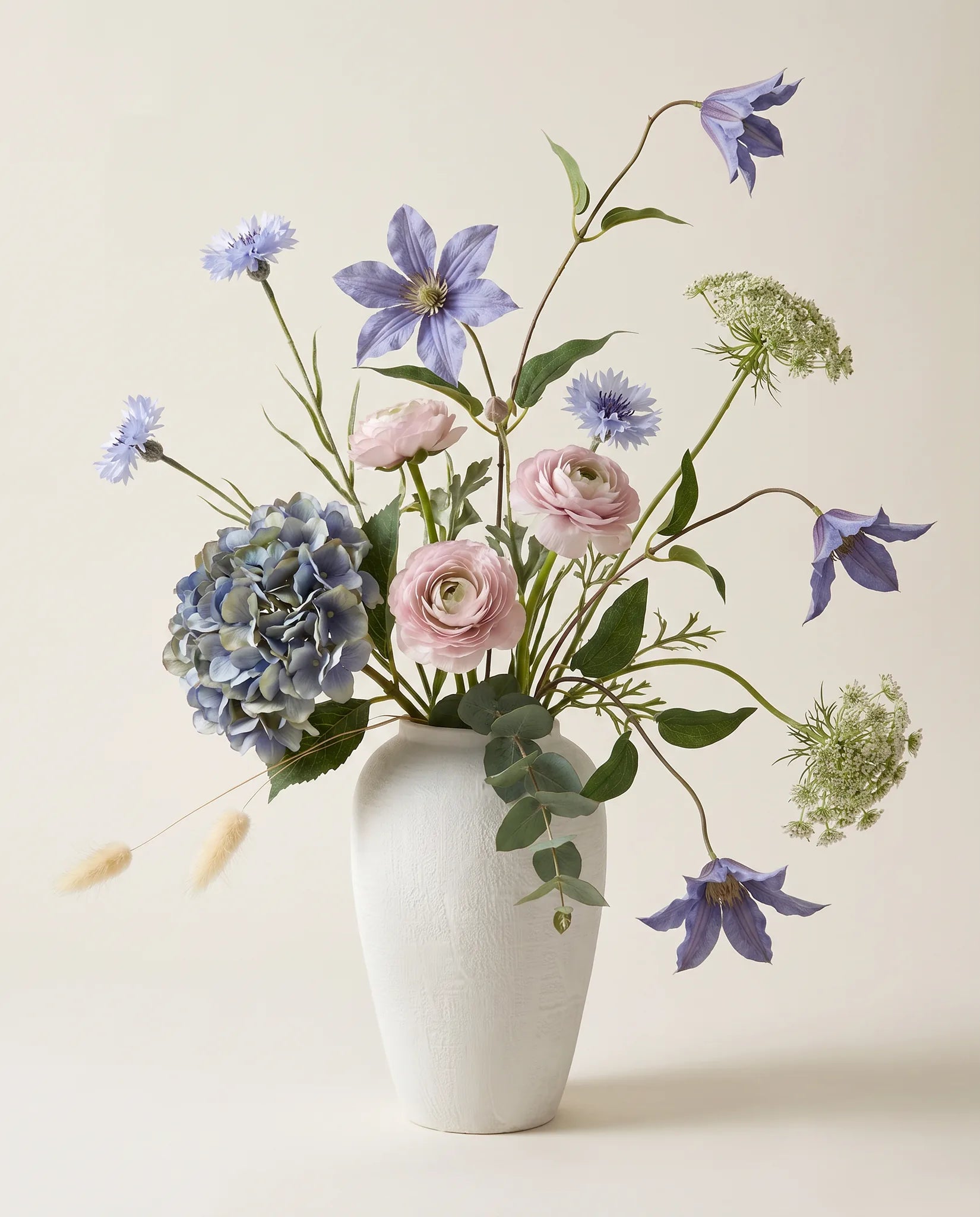 Bouquet artificiel d'hortensias, clématites et renoncules bleu et rose en gros plan