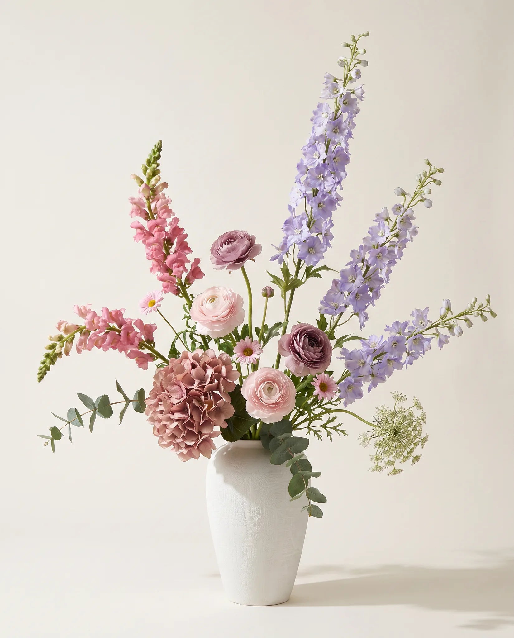 Bouquet artificiel d'hortensias, delphiniums et renoncules violet et rose en gros plan