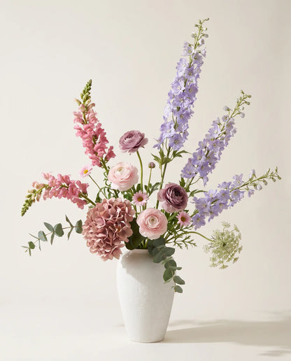 Bouquet artificiel d'hortensias, delphiniums et renoncules violet et rose en gros plan