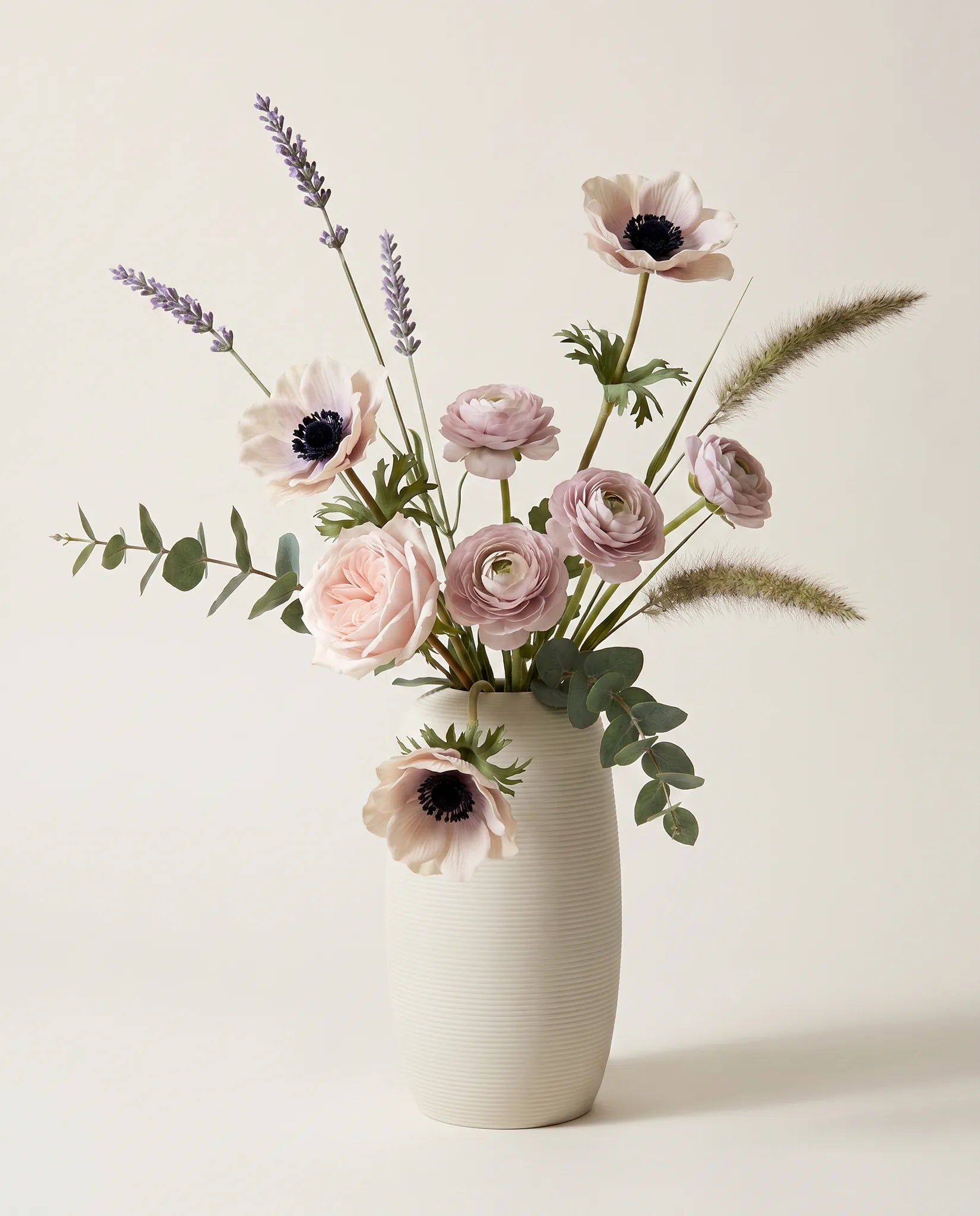 Bouquet artificiel de roses, anémones et renoncules rose et violet en gros plan