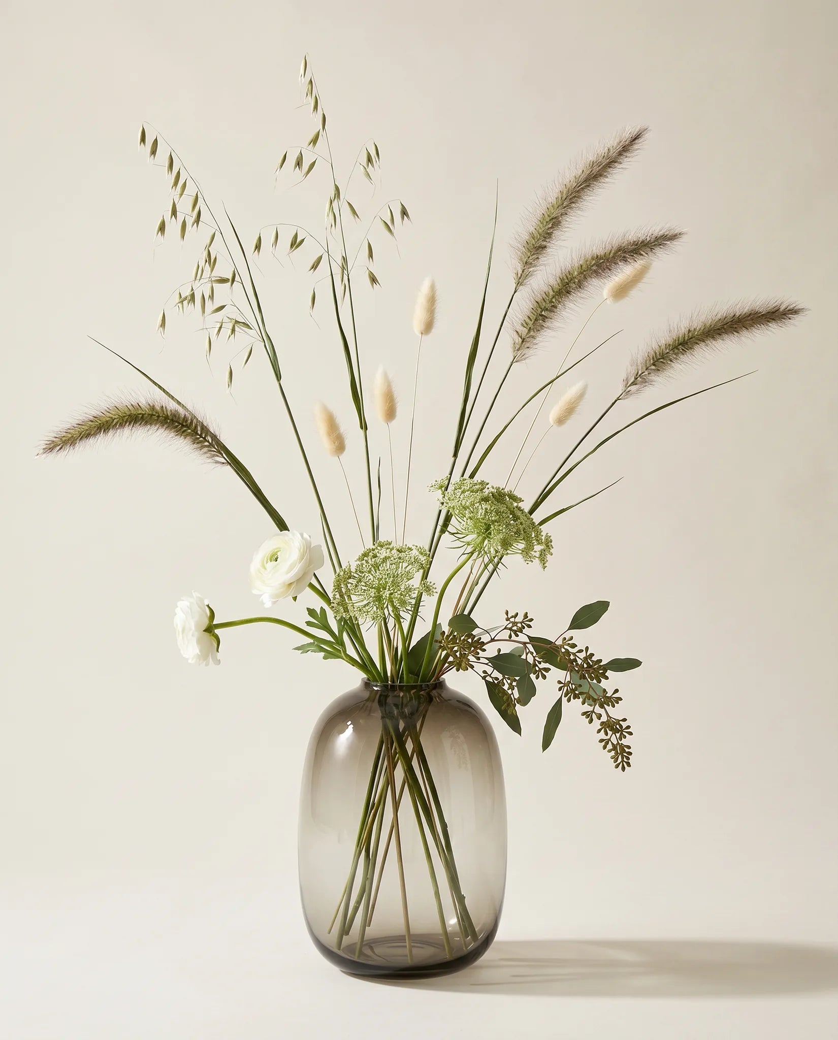 Bouquet artificiel de renoncules, pennisetum et lagurus vert et blanc en gros plan