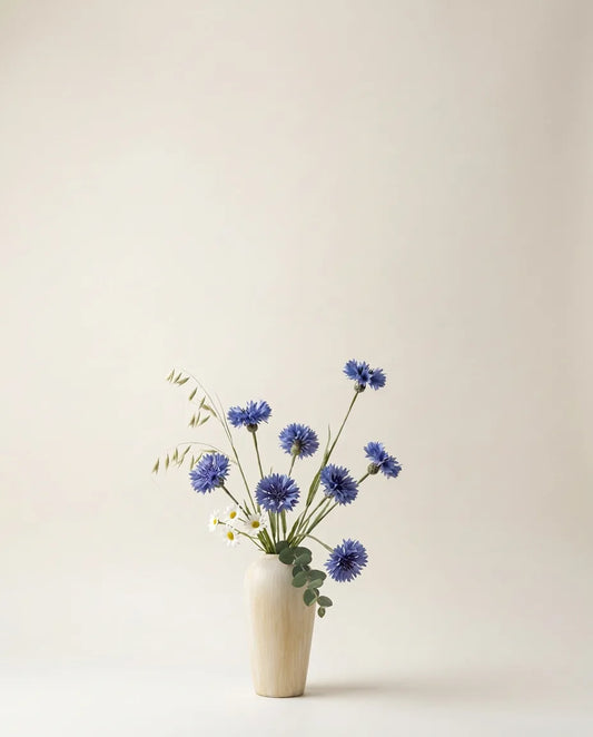 Bouquet artificiel de scabiosa et marguerites blanc et bleu dans un vase en céramique