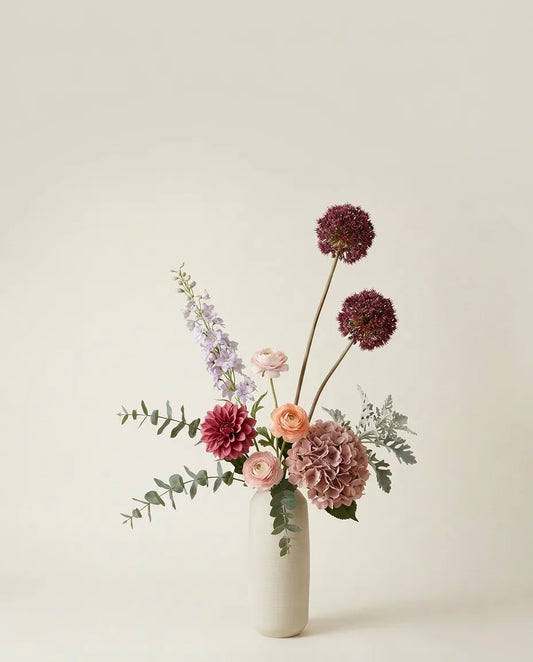 Bouquet artificiel de dahlias, hortensias et renoncules rose et violet dans un vase en céramique