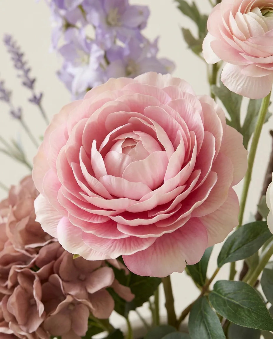 Gros plan sur les renoncules artificielles du bouquet Jardin Pastel XL