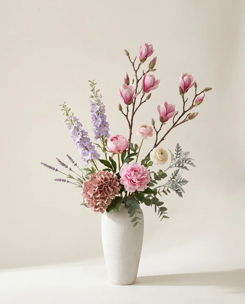 Bouquet artificiel de magnolias, pivoines et hortensias rose et violet dans un vase en céramique
