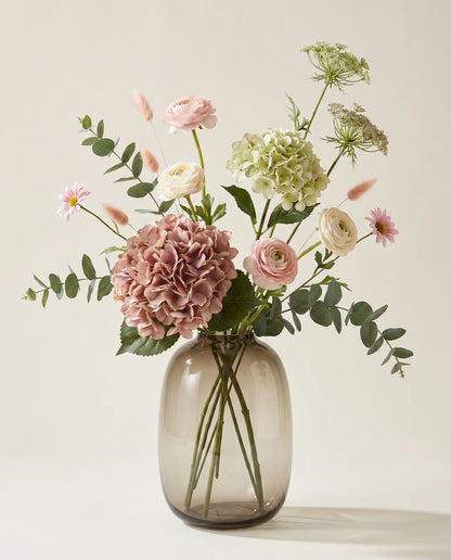 Bouquet artificiel d'hortensias, renoncules et marguerites rose et vert en gros plan