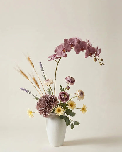 Bouquet artificiel d'orchidées, hortensias et renoncules violet et jaune dans un vase en céramique