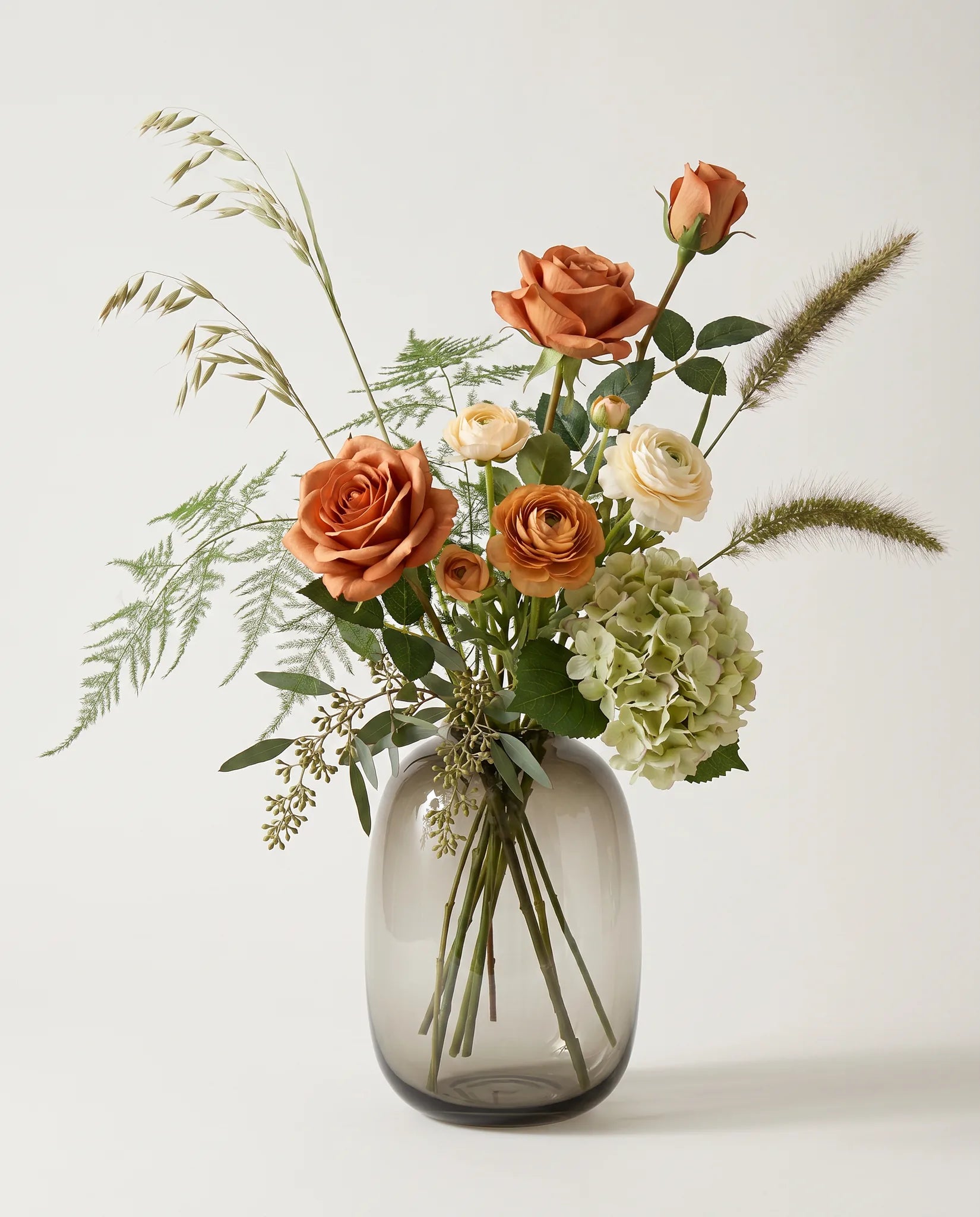 Bouquet artificiel de roses, hortensias et renoncules orange et vert en gros plan