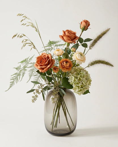 Bouquet artificiel de roses, hortensias et renoncules orange et vert en gros plan