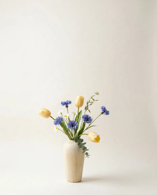 Bouquet artificiel de tulipes et marguerites jaune et bleu dans un vase en céramique