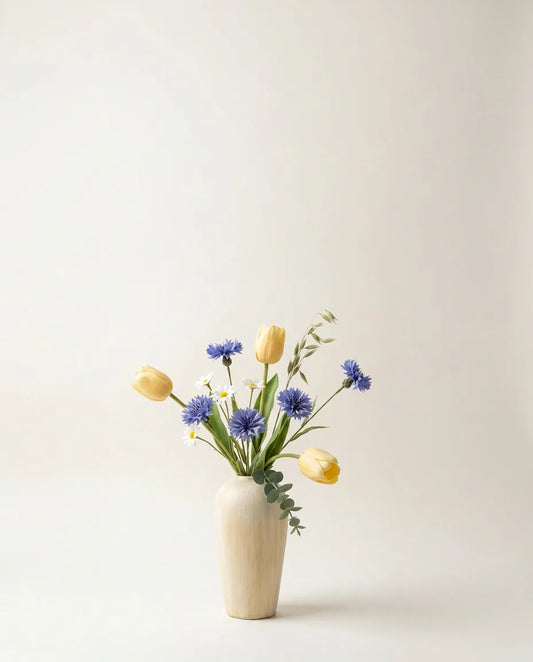 Bouquet artificiel de tulipes et marguerites jaune et bleu dans un vase en céramique