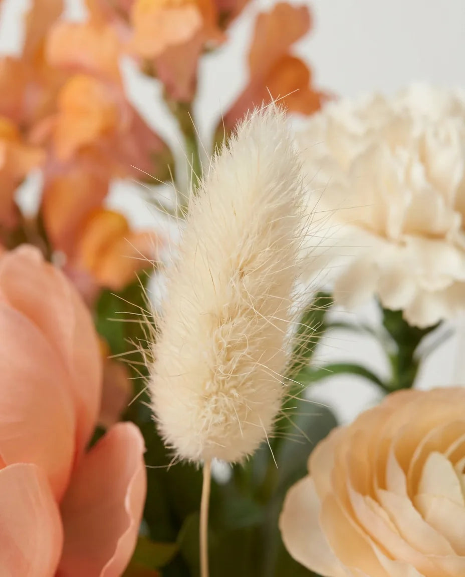 Gros plan sur les lagurus artificiels du bouquet Pêche Melba