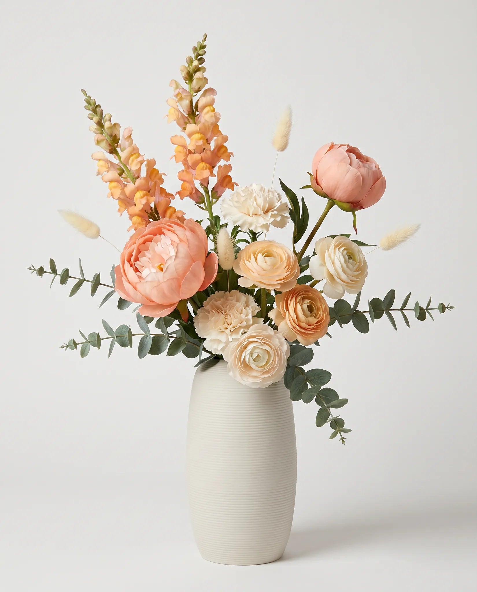 Bouquet artificiel de pivoines, renoncules et œillets orange et blanc en gros plan
