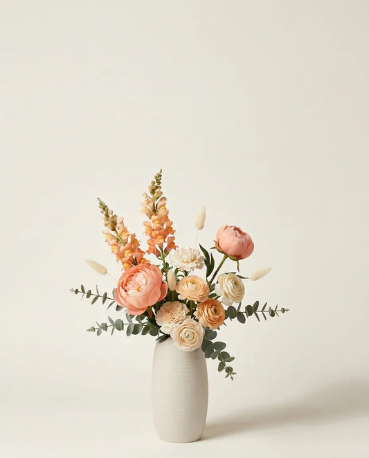 Bouquet artificiel de pivoines, renoncules et œillets orange et blanc dans un vase en céramique