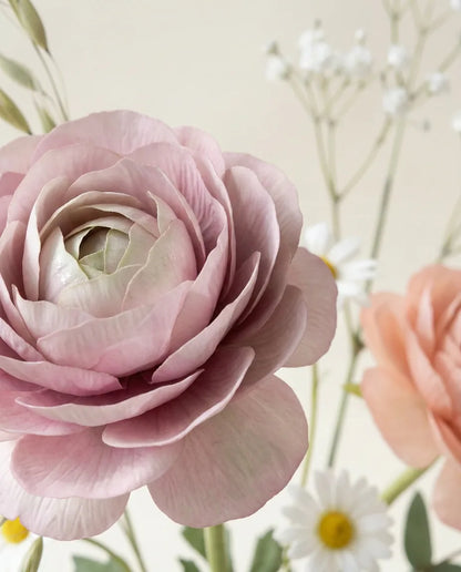 Gros plan sur les renoncules artificielles du bouquet Petit Jardin