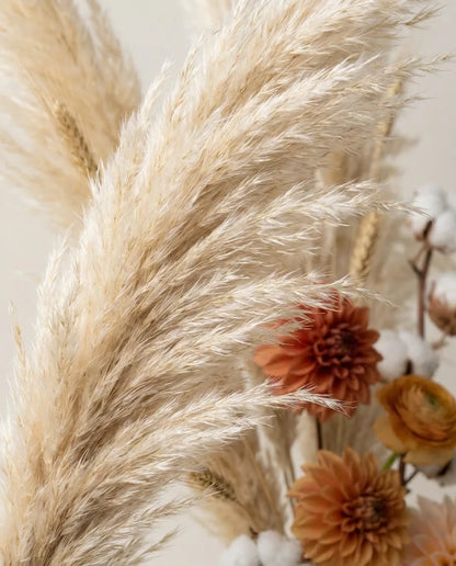 Gros plan sur les plumes de pampa artificielle du bouquet Terre de Sienne