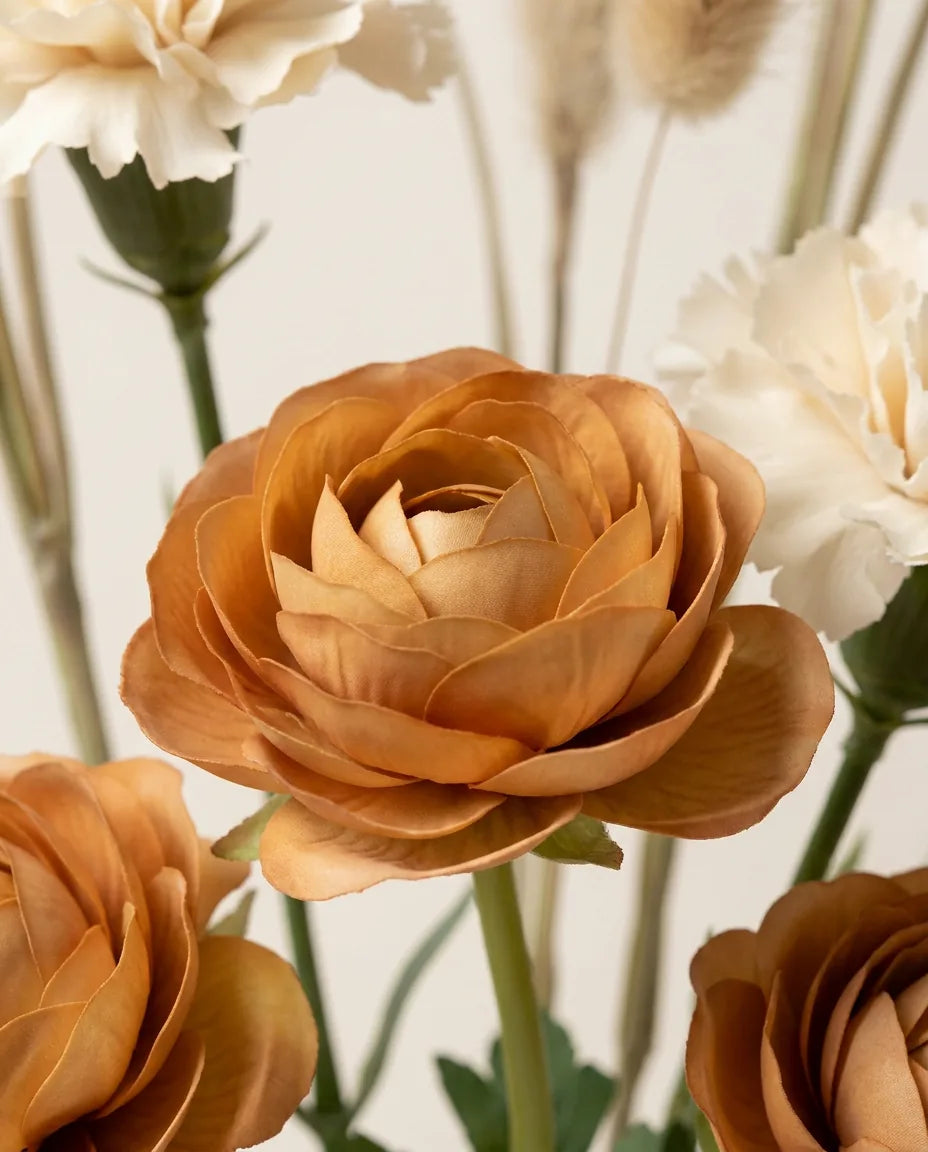 Gros plan sur les renoncules artificielles du bouquet Désert Doux