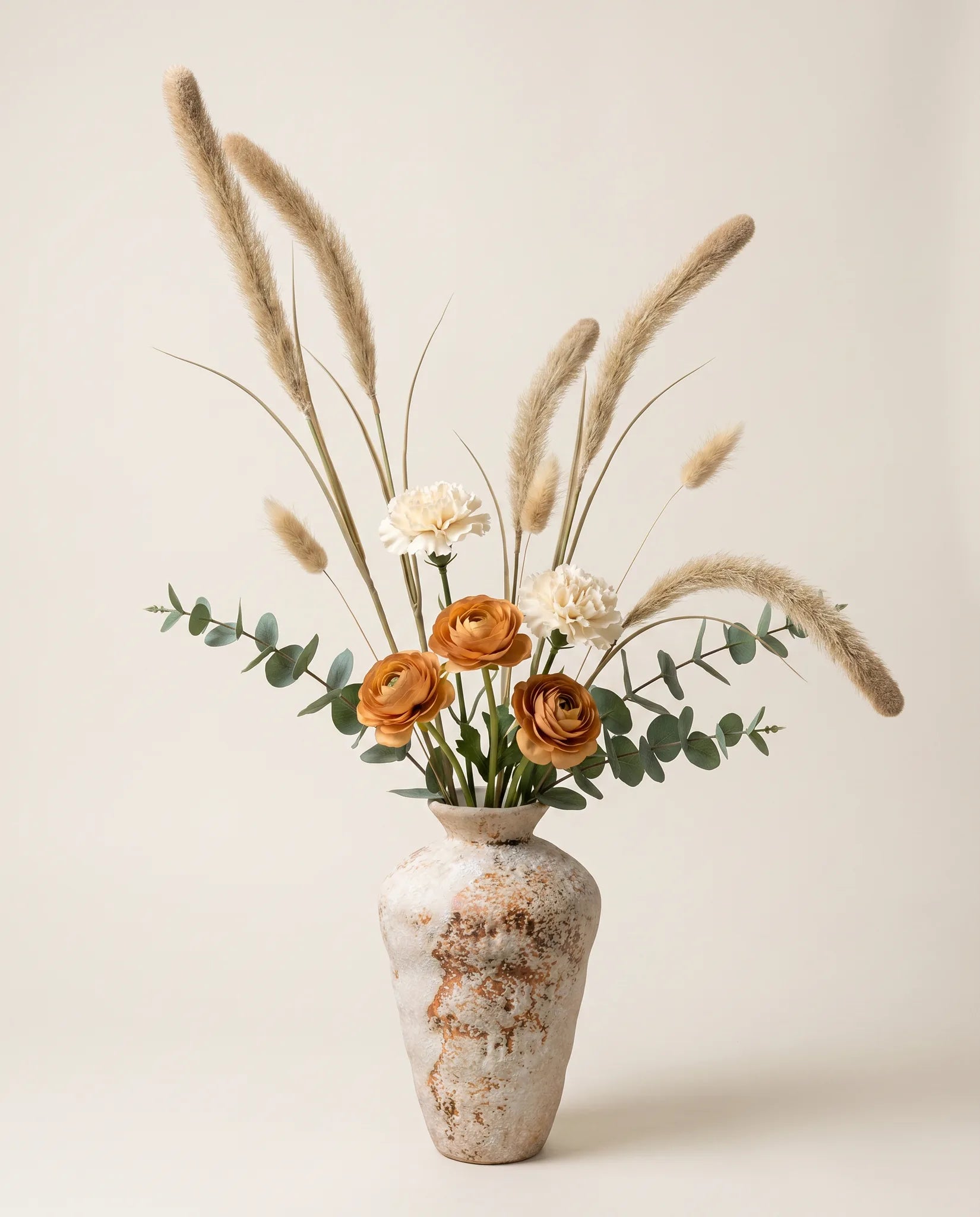Bouquet artificiel de renoncules, œillets et pennisetum beige en gros plan