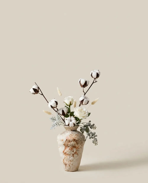 Bouquet artificiel de roses, coton et lagurus blanc et beige dans un vase en céramique