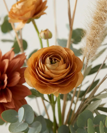 Gros plan sur les renoncules artificielles du bouquet Savane