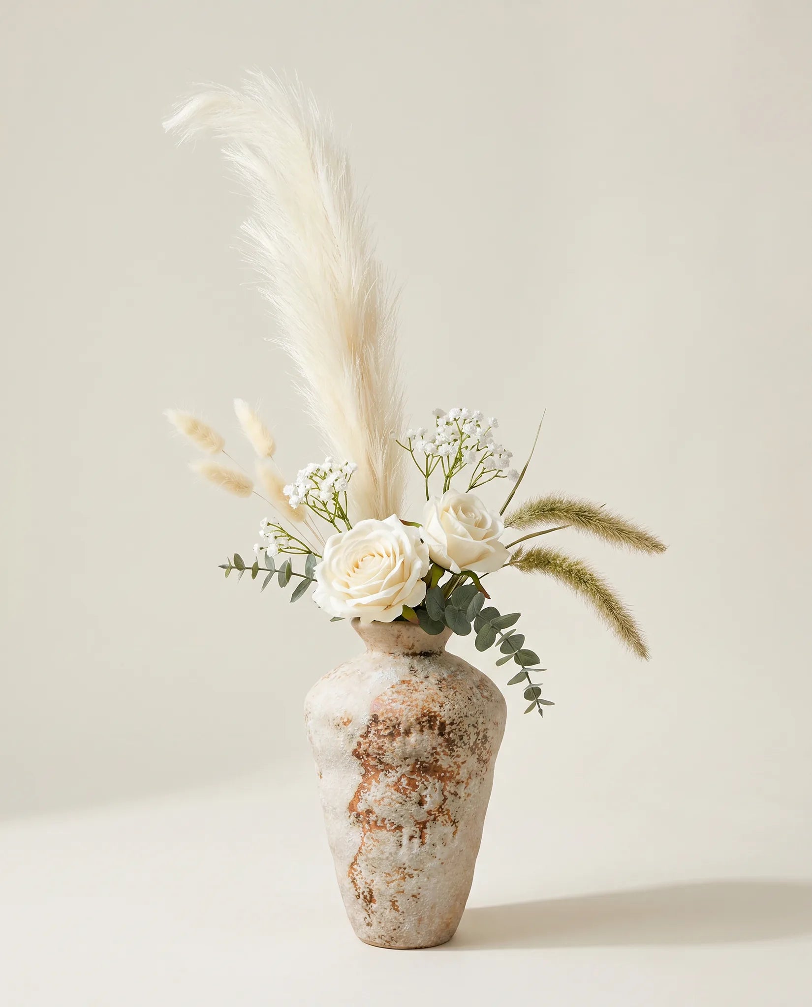 Bouquet artificiel de roses, pennisetum et eucalyptus blanc et beige en gros plan