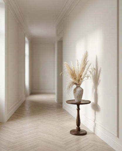 Bouquet artificiel beige et rose sur un guéridon en bois foncé dans un couloir