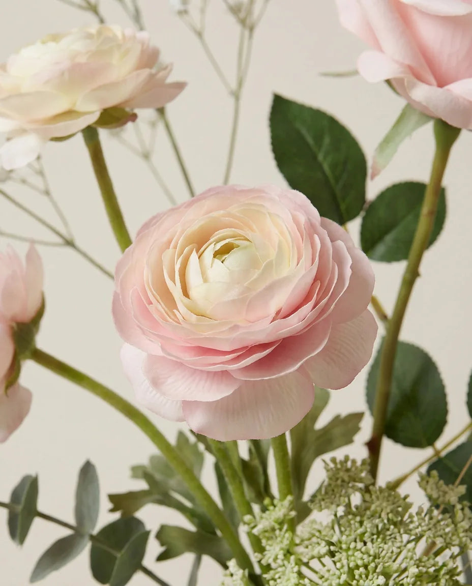 Gros plan sur les renoncules artificielles du bouquet Premier Amour