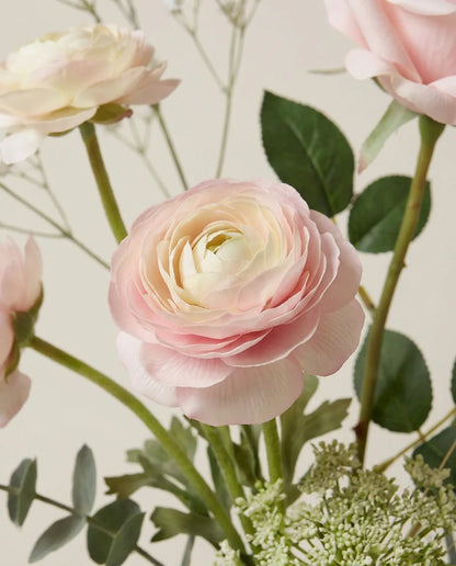 Gros plan sur les renoncules artificielles du bouquet Premier Amour