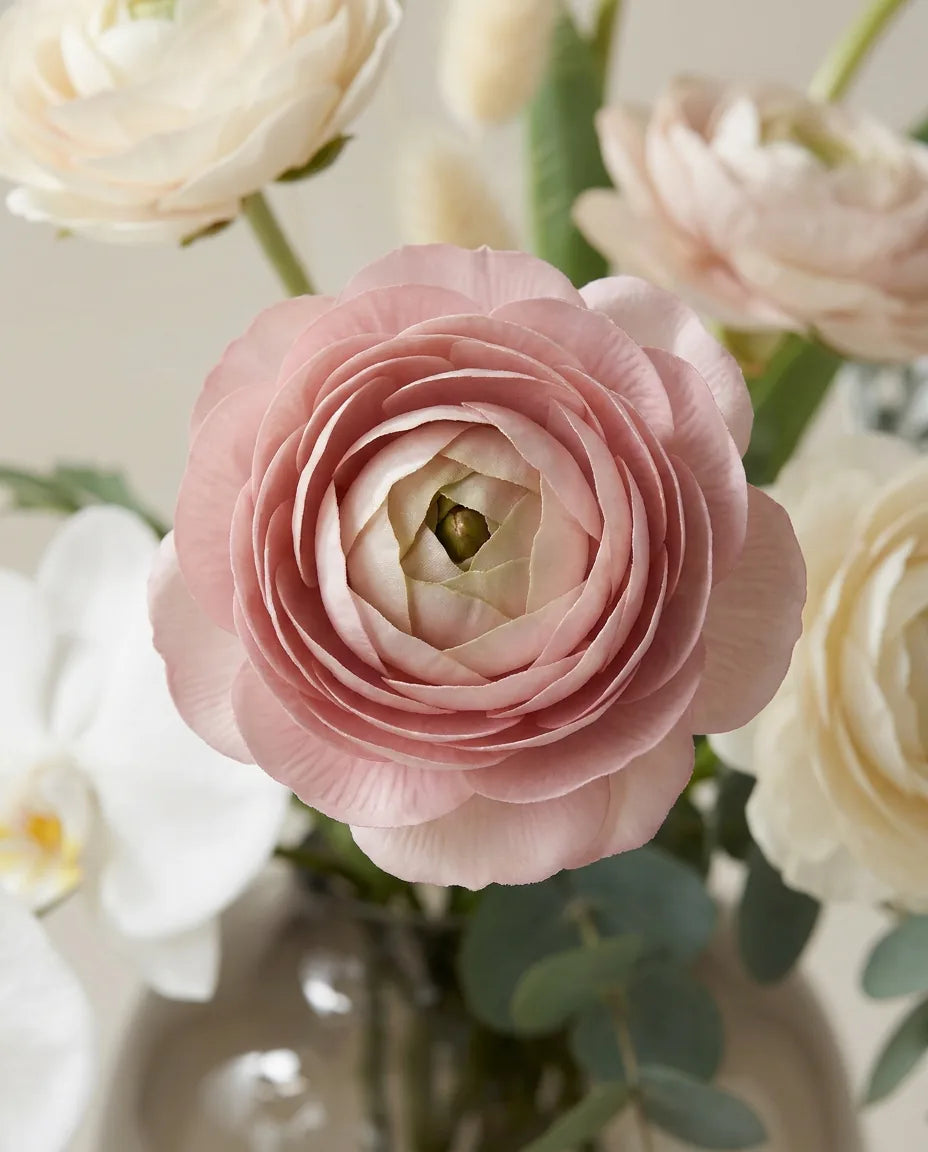 Gros plan sur les renoncules artificielles du bouquet Poudre de Soie