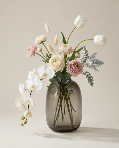 Bouquet artificiel d'orchidées, renoncules et tulipes blanc et rose en gros plan
