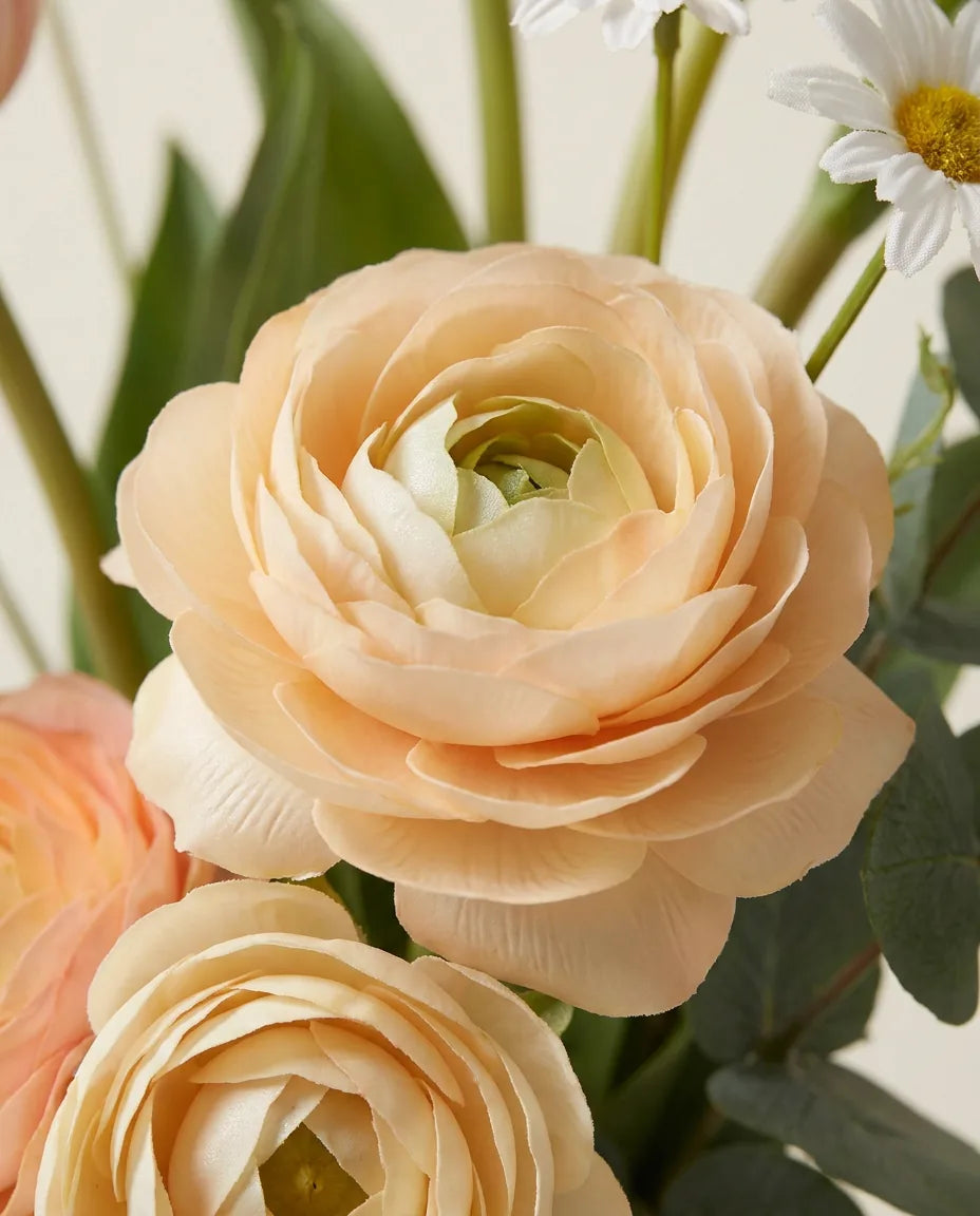 Gros plan sur les renoncules artificielles du bouquet Aurore