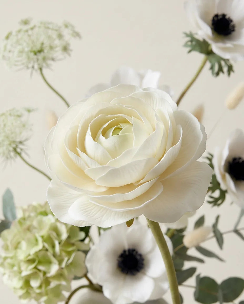 Gros plan sur les renoncules artificielles du bouquet Valse Blanche