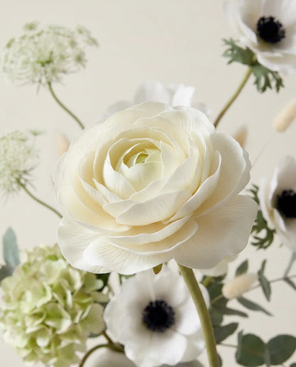 Gros plan sur les renoncules artificielles du bouquet Valse Blanche