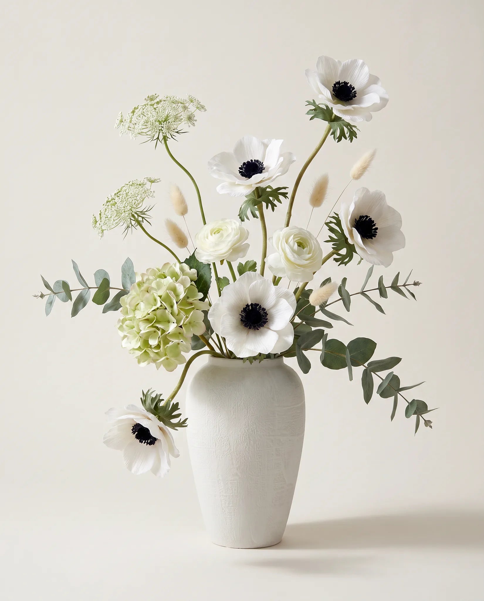 Bouquet artificiel d'hortensias, anémones et renoncules blanc et vert en gros plan