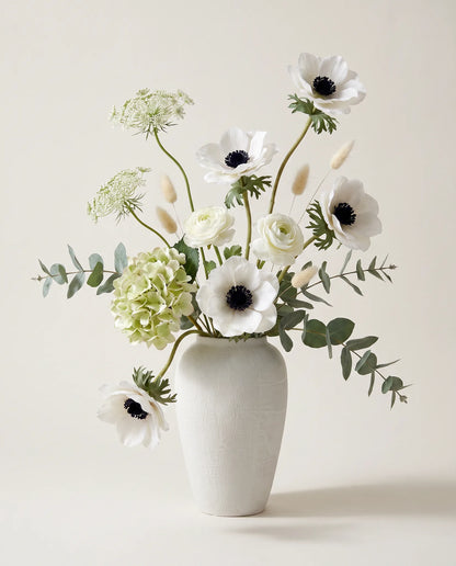 Bouquet artificiel d'hortensias, anémones et renoncules blanc et vert en gros plan