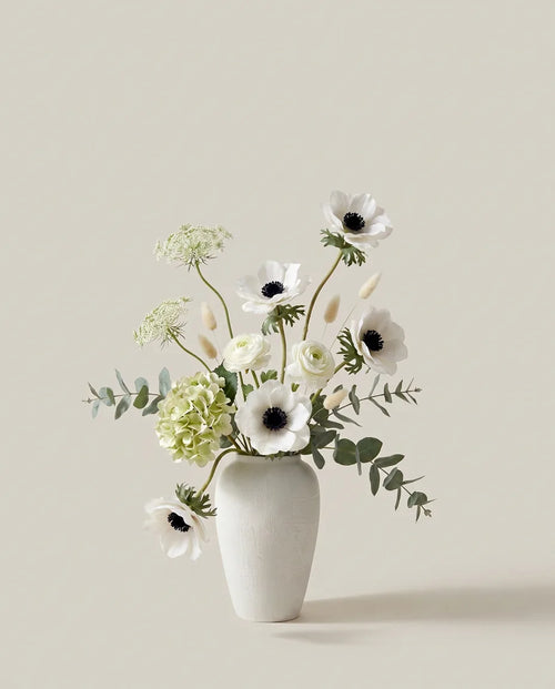 Bouquet artificiel d'hortensias, anémones et renoncules blanc et vert dans un vase en céramique