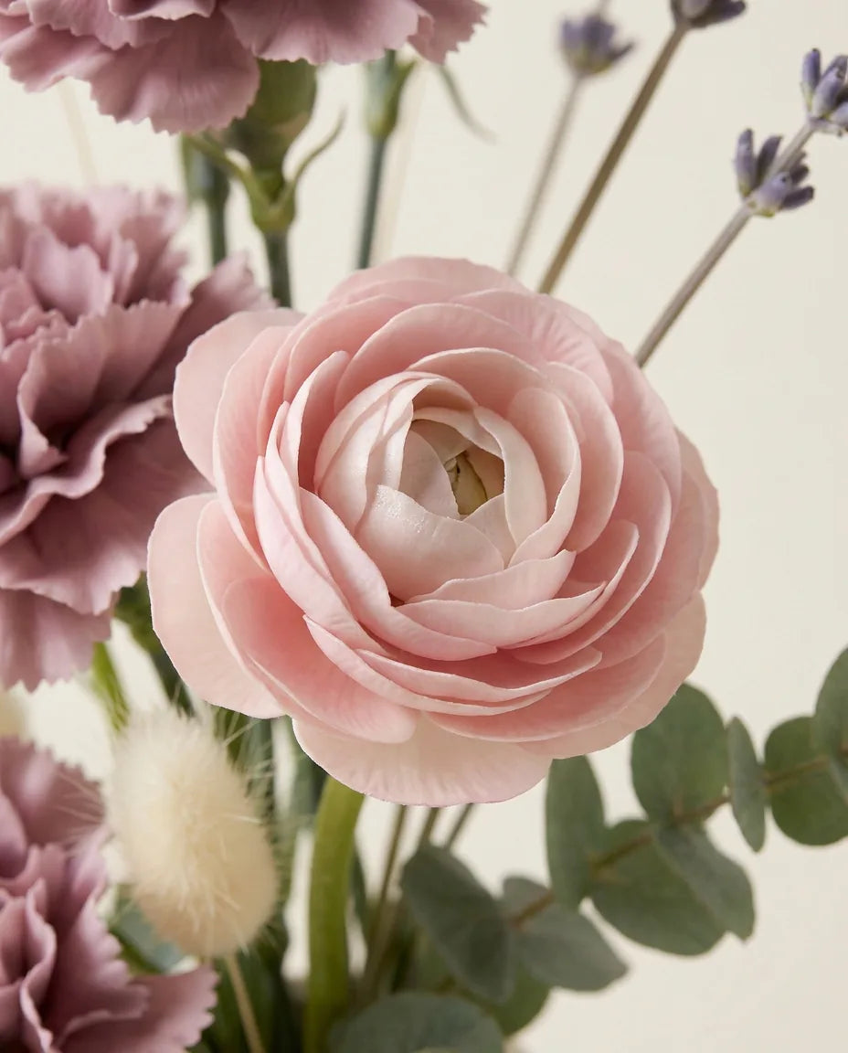 Gros plan sur les renoncules artificielles du bouquet Romance Mauve