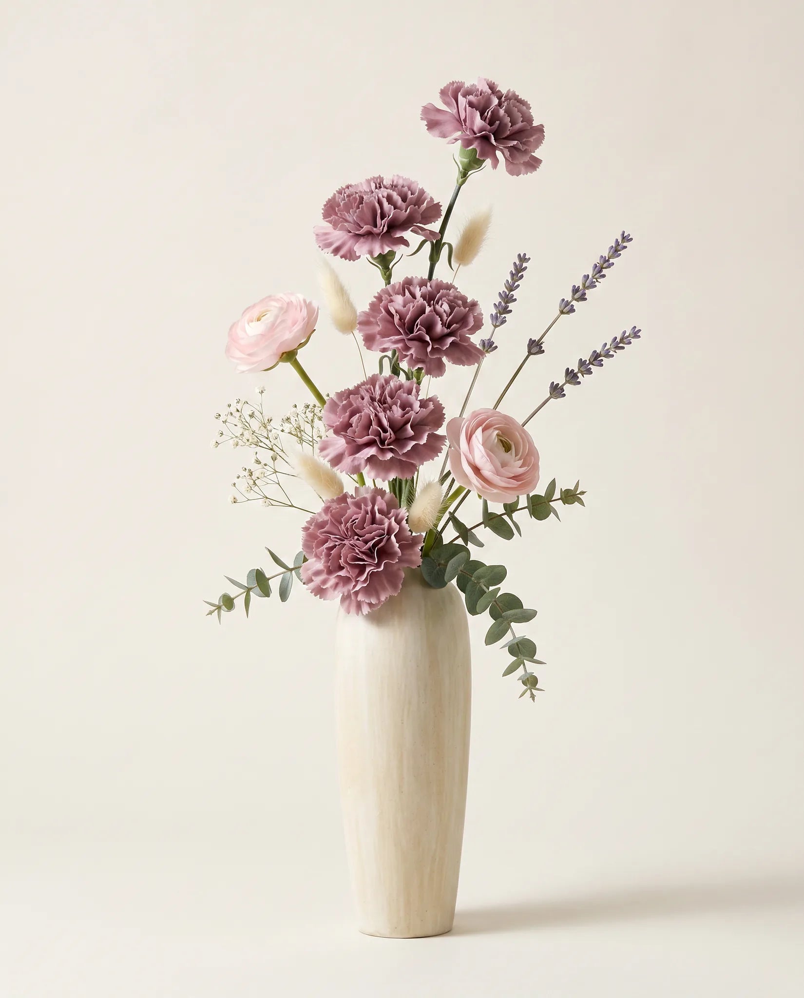Bouquet artificiel d'œillets, lavande et renoncules violet et rose en gros plan