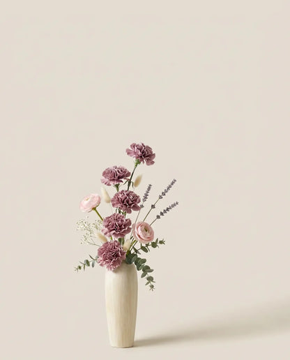 Bouquet artificiel d'œillets, lavande et renoncules violet et rose dans un vase en céramique