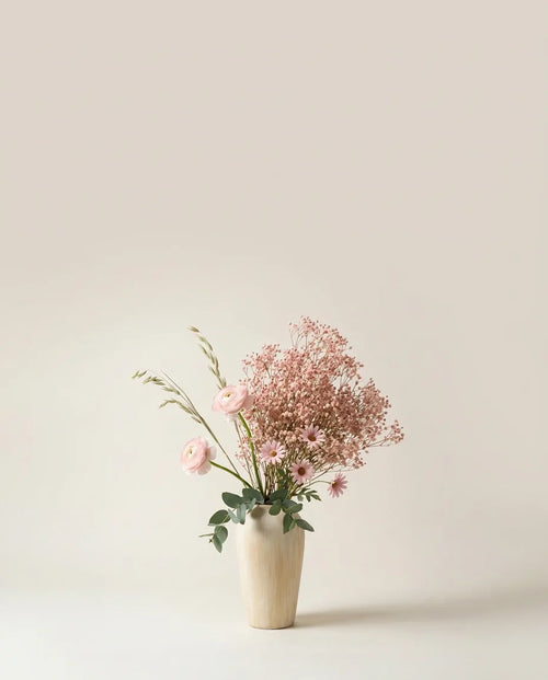 Bouquet artificiel de marguerites, renoncules et gypsophile rose et blanc dans un vase en céramique
