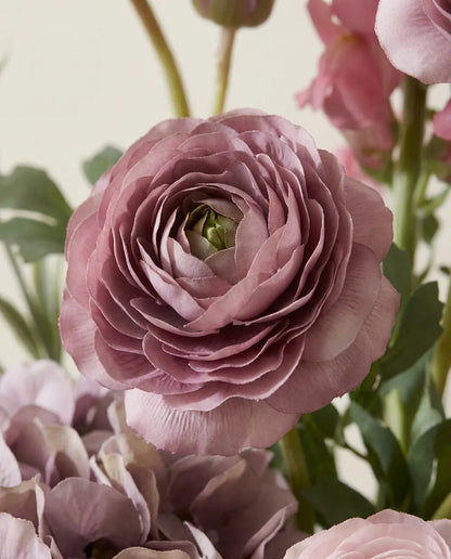 Gros plan sur les renoncules artificielles du bouquet Élégie Rose