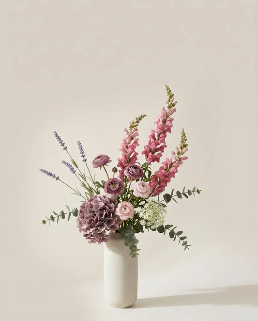 Bouquet artificiel d'hortensias, mufliers et renoncules rose et violet dans un vase en céramique