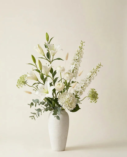 Bouquet artificiel de lys, hortensias et renoncules blanc et vert dans un vase en céramique