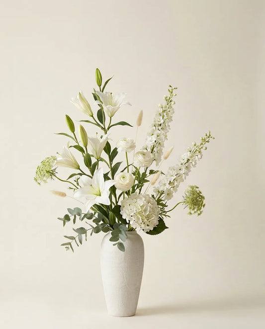 Bouquet artificiel de lys, hortensias et renoncules blanc et vert dans un vase en céramique