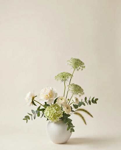 Bouquet artificiel de pivoines, hortensias et renoncules blanc et vert dans un vase en céramique