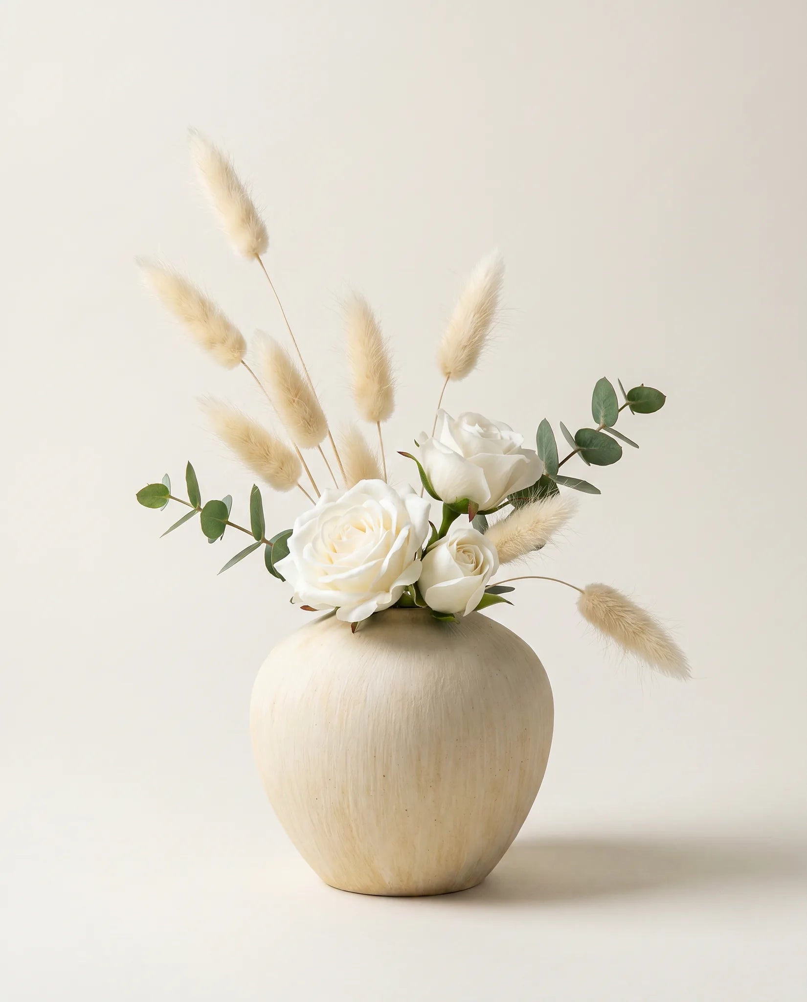 Bouquet artificiel de roses, lagurus et eucalyptus blanc et vert en gros plan