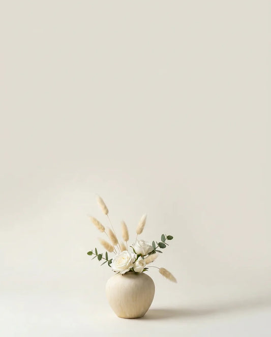 Bouquet artificiel de roses, lagurus et eucalyptus blanc et vert dans un vase en céramique