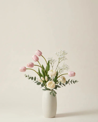 Bouquet artificiel de tulipes, renoncules et lagurus rose et blanc dans un vase en céramique